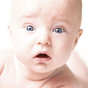 Ein Baby schaut staunend in die Kamera.